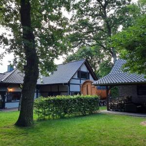 a house with a tree in the yard at Heuerhaus Gut Einhaus in Werlte