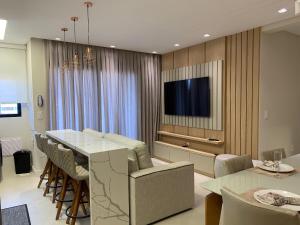sala de estar con mesa y TV en Residencial Waldgarten Bombinhas en Bombinhas