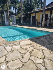 uma piscina num quintal com uma casa em solar das margaridas em Paraty