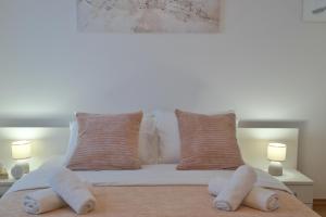 1 cama blanca con 2 almohadas y 2 lámparas en Apartman Čakovec, en Čakovec