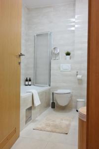 a white bathroom with a toilet and a shower at Apartman Čakovec in Čakovec