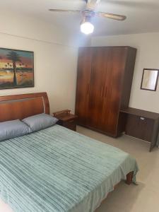 1 dormitorio con 1 cama y armario de madera en Férias na Praia dos Ingleses, en Florianópolis