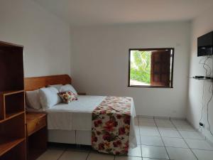 um quarto com uma cama e uma janela em POUSADA TOCA DO LOBO na Ilha de Boipeba