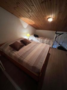 - une chambre avec un grand lit et un plafond en bois dans l'établissement Appartement 6 couchages La Foux d’Allos, à Allos