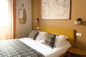 una camera da letto con un letto con cuscini sopra di Le Magnan ad Avignone