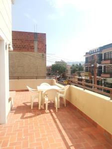 a patio with two chairs and a table on a roof at Hostal Palamas in Tarija