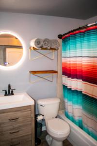a bathroom with a toilet and a colorful shower curtain at The Three Keys duplex in Sedona