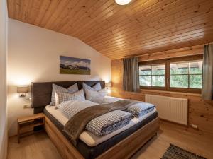 ヴェステンドルフにあるAppartement Margarethaの木製の部屋に大型ベッドが備わるベッドルーム1室が備わります。
