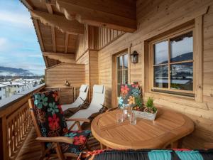 a wooden porch with a wooden table and chairs at Appartement Margaretha in Westendorf