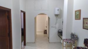 un corridoio con pareti bianche e una porta con sedie di Studio Au Centre Ville Prés de la Medina a Fes