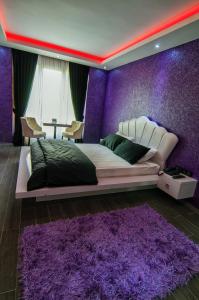 イスタンブールにあるAg Şişli Hotelの紫色の壁のベッドルーム(大型ベッド1台付)