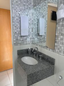 a bathroom with a sink and a mirror at HOTEL E POUSADA ISIS in São Pedro