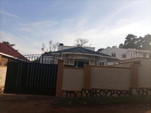 ein Haus mit einem Tor und einem Zaun in der Unterkunft Pearl Motel Buloba in Buloba
