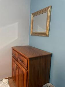 a wooden dresser with a mirror on a wall at VILLAS MARCO POLO in Panajachel