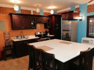a kitchen with a table and a refrigerator at VILLAS MARCO POLO in Panajachel