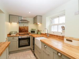 a kitchen with wooden counter tops and a sink at Granary Cottage in Warminster