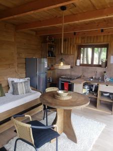 a kitchen and living room with a table and a bed at Cabañas Vasconia in Castro