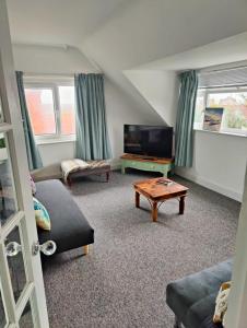 a living room with a tv and a coffee table at Bexhill Sea View Flat 3 in Bexhill