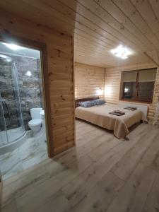 a bedroom with a bed in a wooden cabin at У Мирослави in Pilipets