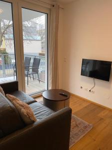 sala de estar con sofá y TV de pantalla plana en Modern apartment with balcony near city center, en Viena