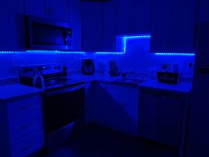 een keuken met blauwe verlichting in een donkere kamer bij *NEWLY RENOVATED* COZY 2 BDRM ENTIRE APT in Tacoma