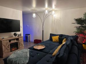 een woonkamer met een blauwe bank en een tv bij *NEWLY RENOVATED* COZY 2 BDRM ENTIRE APT in Tacoma