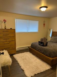een slaapkamer met een bed, een dressoir en een tapijt bij *NEWLY RENOVATED* COZY 2 BDRM ENTIRE APT in Tacoma