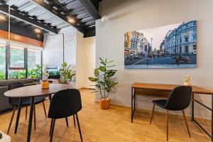 - un salon avec une table et des chaises ainsi qu'une peinture murale dans l'établissement Signature by VH Lofts & apartments Roma Norte, à Mexico