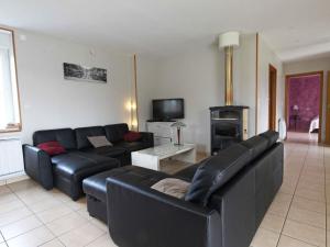uma sala de estar com um sofá de couro preto e uma lareira em Gîte Landisacq, 6 pièces, 12 personnes - FR-1-497-167 em Landisacq