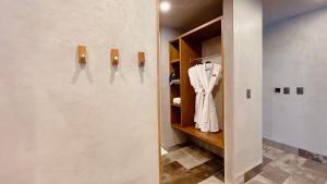 a room with a closet with a robe in it at Hotel Amainah Bacalar Adults Only in Bacalar +42 photos