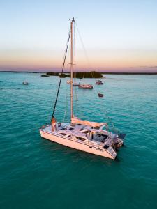a white boat in the water with a person on it at Hotel Amainah Bacalar in Bacalar