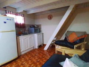 uma cozinha com um frigorífico e um sofá num quarto em La Serena em Mar de Ajó