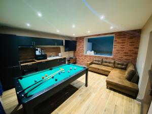 a living room with a pool table and a couch at Un moment hors du temps - Jacuzzi - Sauna - Billard -Baby-Foot- Parking - 167 in Rouen