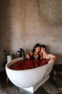 a man and woman sitting in a bath tub with flowers at Hotel Amainah Bacalar in Bacalar