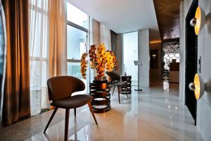 a lobby with a bunch of chairs and a plant at Sandri Palace Hotel in Itajaí