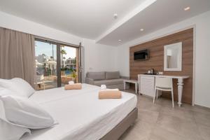 a bedroom with a bed and a desk and a table at Apollon Hotel in Kos