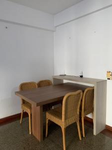 una mesa de madera y sillas con mesa, mesa y sillas en Scala Residence particular, en Fortaleza