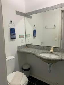 y baño con lavabo, aseo y espejo. en Scala Residence particular, en Fortaleza