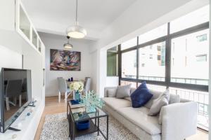 ein Wohnzimmer mit Sofa und Fernseher in der Unterkunft MARBELLA BANUS SUITES - Marbella Centre Soriano Suite Apartment in Marbella