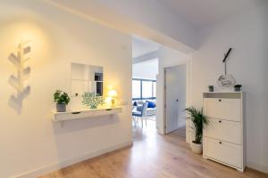 ein Wohnzimmer mit weißen Wänden und einem Tisch mit Pflanzen in der Unterkunft MARBELLA BANUS SUITES - Marbella Centre Soriano Suite Apartment in Marbella