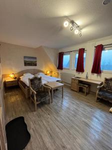 Schlafzimmer mit einem Bett, einem Schreibtisch und einem Waschbecken in der Unterkunft Hotel Clemens in Winterberg