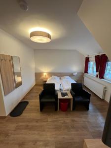 a room with a bed and two chairs and a table at Hotel Clemens in Winterberg