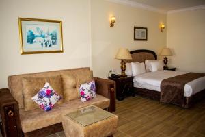 Palma Di Sharm Hollywood Resort في شرم الشيخ: غرفة في الفندق مع أريكة وسرير