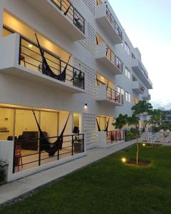 a apartment building with a hammock on the balconies at Papaya Condo Acapulco Diamante -Solo Adultos in Acapulco