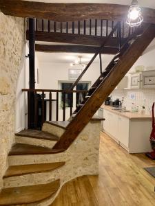 a staircase in a room with a kitchen and a counter at Gîte des Jonchères in Brizambourg