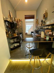 cocina con encimera y taburetes en una habitación en Industrial style loft in the heart of wiesbaden, en Wiesbaden