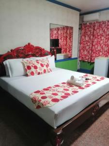 um quarto com uma cama grande e almofadas vermelhas e brancas em Sang Yoo Mountain View Tagaytay Bed and Breakfast - Taal Lake View em Tagaytay