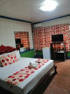 a bedroom with a large bed with red and white sheets at Sang Yoo Mountain View Tagaytay Bed and Breakfast - Taal Lake View in Tagaytay