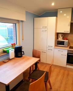 a kitchen with a wooden table and a microwave at City - Appartement in Lengerich