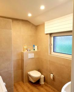 a bathroom with a toilet and a sink and a window at City - Appartement in Lengerich +15 photos